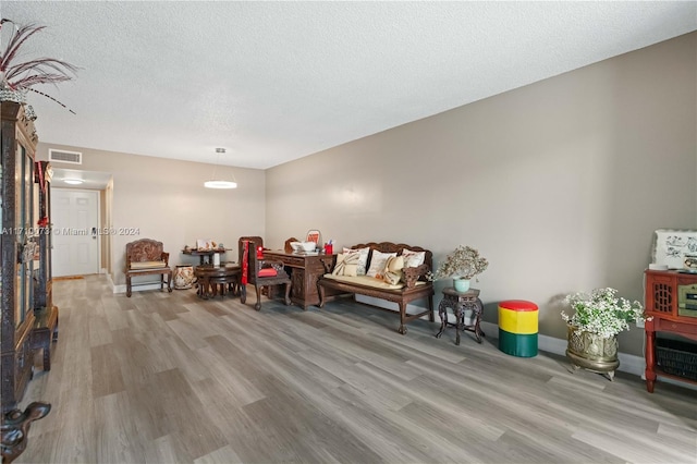 sitting room featuring light wood-type flooring and a textured ceiling