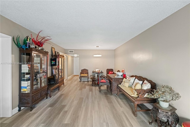 sitting room featuring light hardwood / wood-style flooring and a textured ceiling