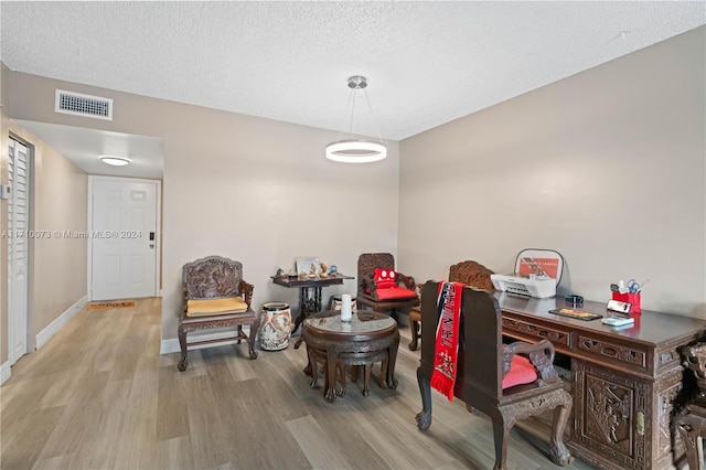 office space featuring a textured ceiling and light hardwood / wood-style flooring