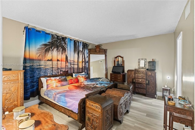 bedroom with light hardwood / wood-style flooring and a textured ceiling