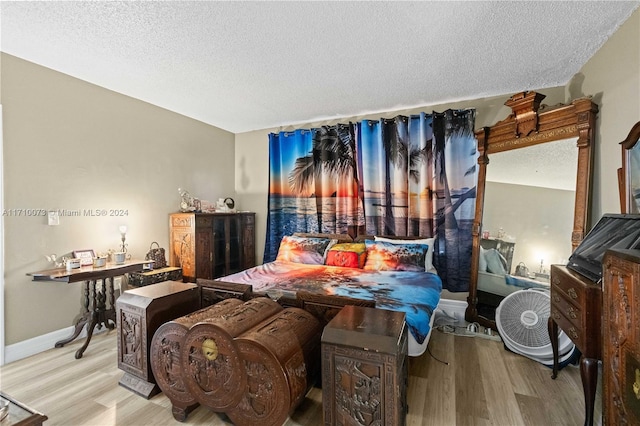 bedroom featuring a textured ceiling and light hardwood / wood-style floors