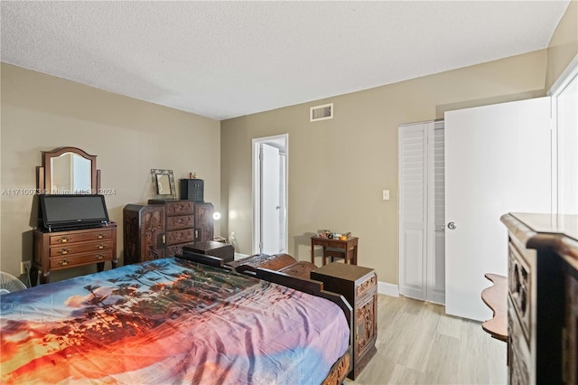 bedroom featuring a textured ceiling and light wood-type flooring