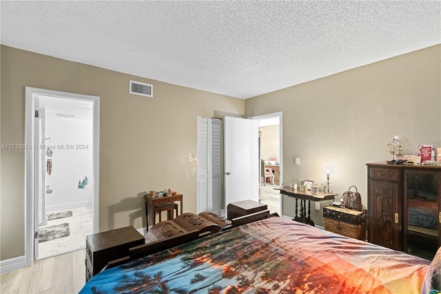 bedroom featuring hardwood / wood-style floors and a textured ceiling