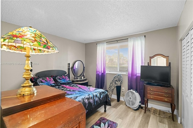 bedroom with light hardwood / wood-style floors and a textured ceiling