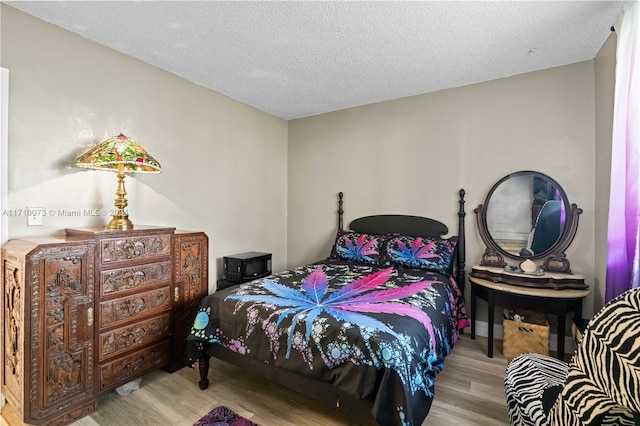 bedroom with light hardwood / wood-style floors and a textured ceiling