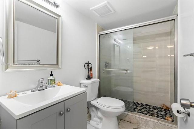 bathroom with a shower with door, vanity, and toilet