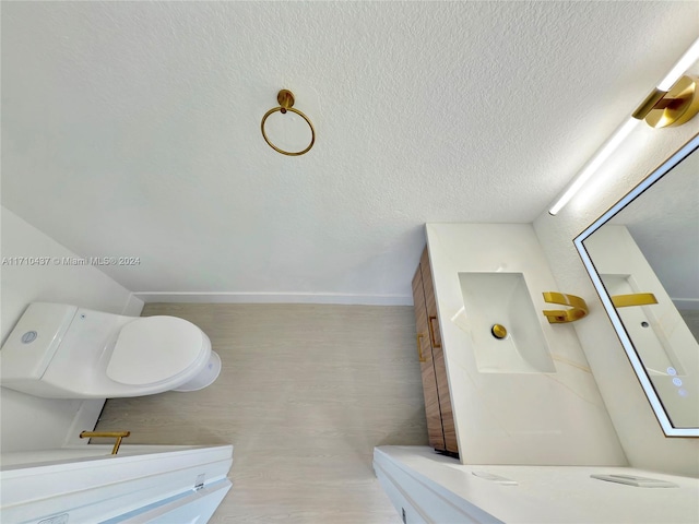 bathroom with toilet and a textured ceiling