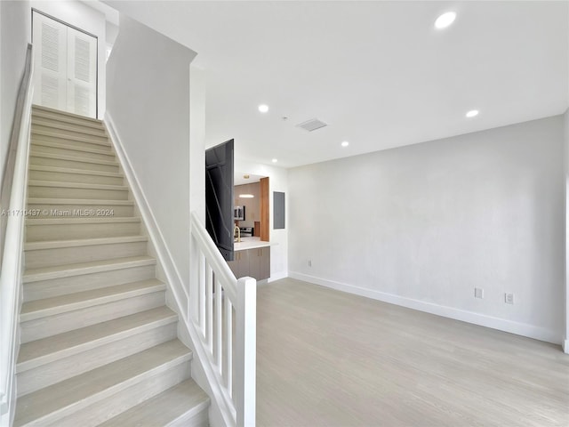 staircase with hardwood / wood-style floors