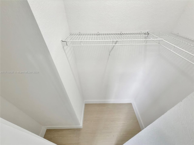 walk in closet with light hardwood / wood-style flooring