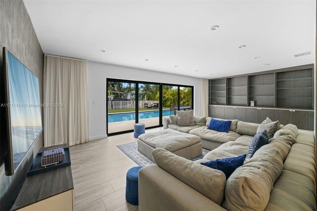 living room featuring built in shelves and light hardwood / wood-style flooring