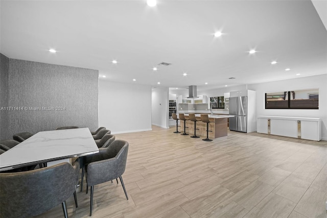 dining space with sink and light wood-type flooring