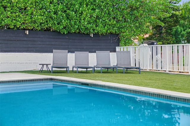 view of swimming pool with a lawn