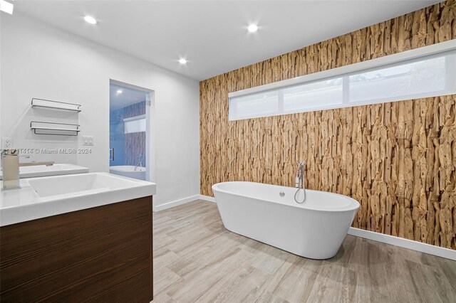 bathroom featuring a washtub, vanity, and wood-type flooring