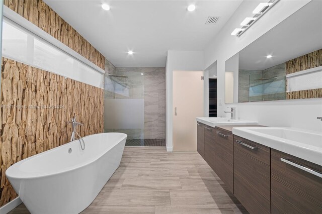 bathroom with vanity, separate shower and tub, and tile walls