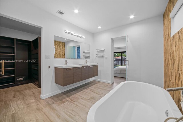 bathroom featuring a washtub, vanity, and wood-type flooring