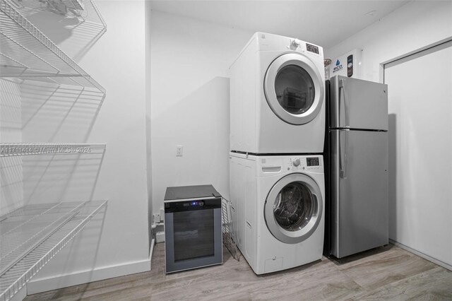 washroom featuring light hardwood / wood-style floors and stacked washer and clothes dryer