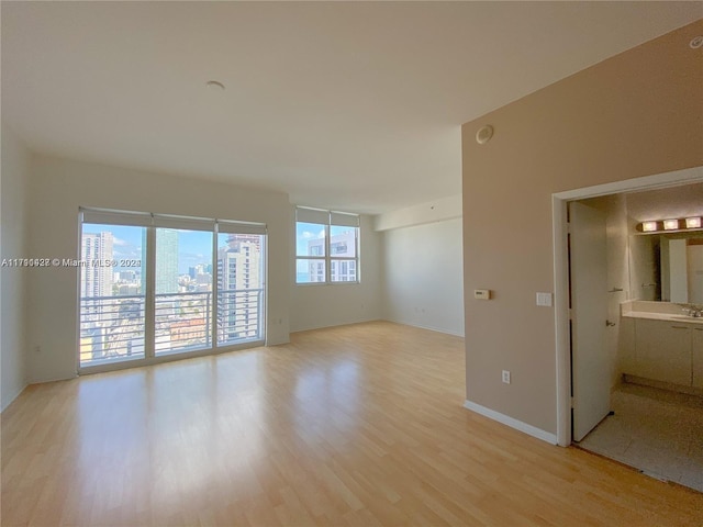 unfurnished room featuring sink and light hardwood / wood-style flooring