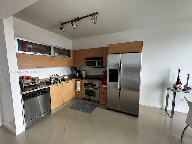 kitchen featuring light tile patterned flooring, appliances with stainless steel finishes, track lighting, and sink