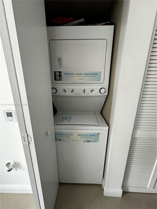 washroom featuring stacked washer and dryer and light tile patterned flooring