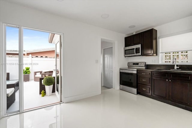 kitchen featuring appliances with stainless steel finishes, dark brown cabinetry, and sink