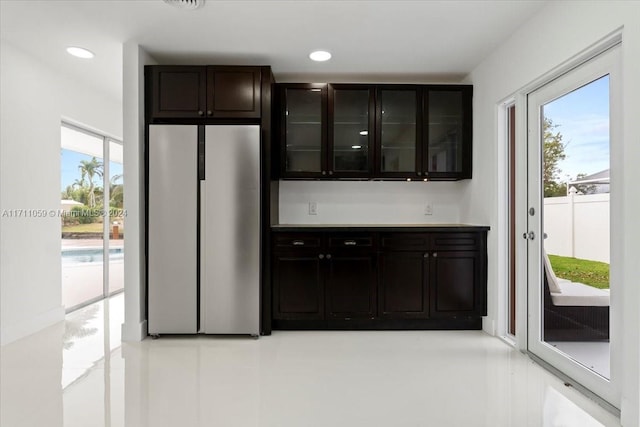 kitchen featuring stainless steel refrigerator and dark brown cabinetry