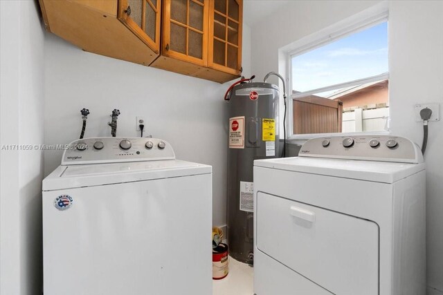 washroom featuring electric water heater and washer and dryer