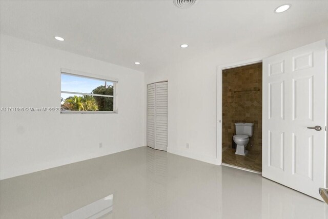 unfurnished bedroom featuring ensuite bathroom and a closet