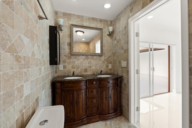 bathroom with vanity and tile walls