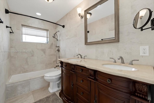 bathroom featuring a tile shower, vanity, tile walls, and toilet