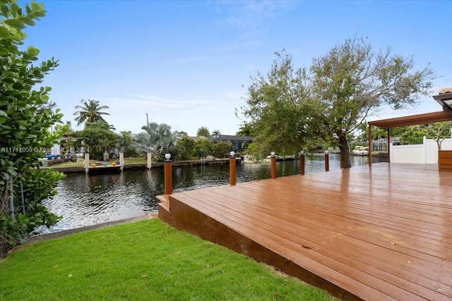 dock area with a lawn and a water view