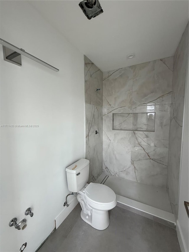 bathroom with toilet, concrete flooring, and tiled shower