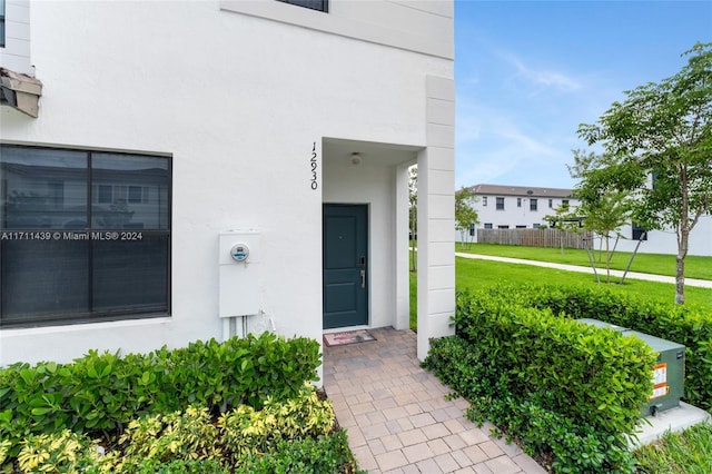 view of exterior entry featuring a yard