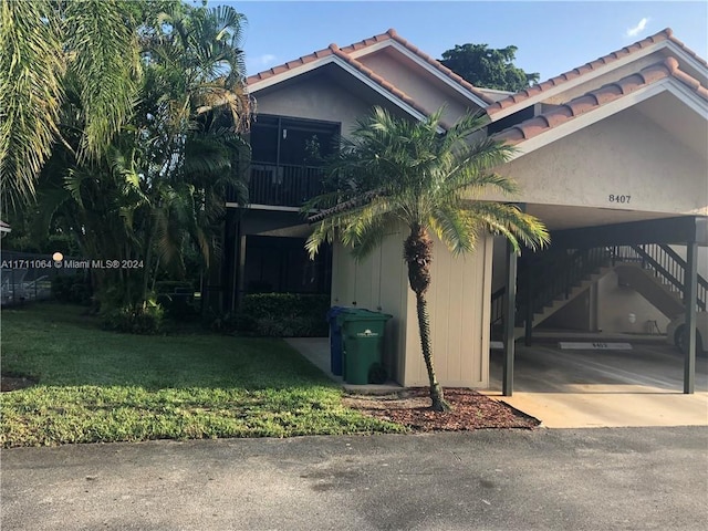 view of side of home featuring a lawn and a carport