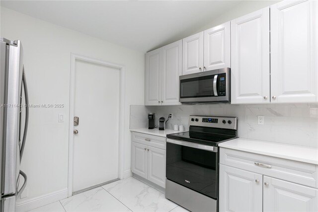 kitchen featuring white cabinets, appliances with stainless steel finishes, and backsplash