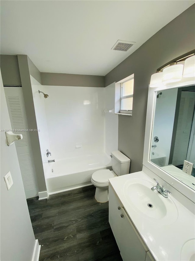 full bathroom with vanity, hardwood / wood-style floors, bathtub / shower combination, and toilet