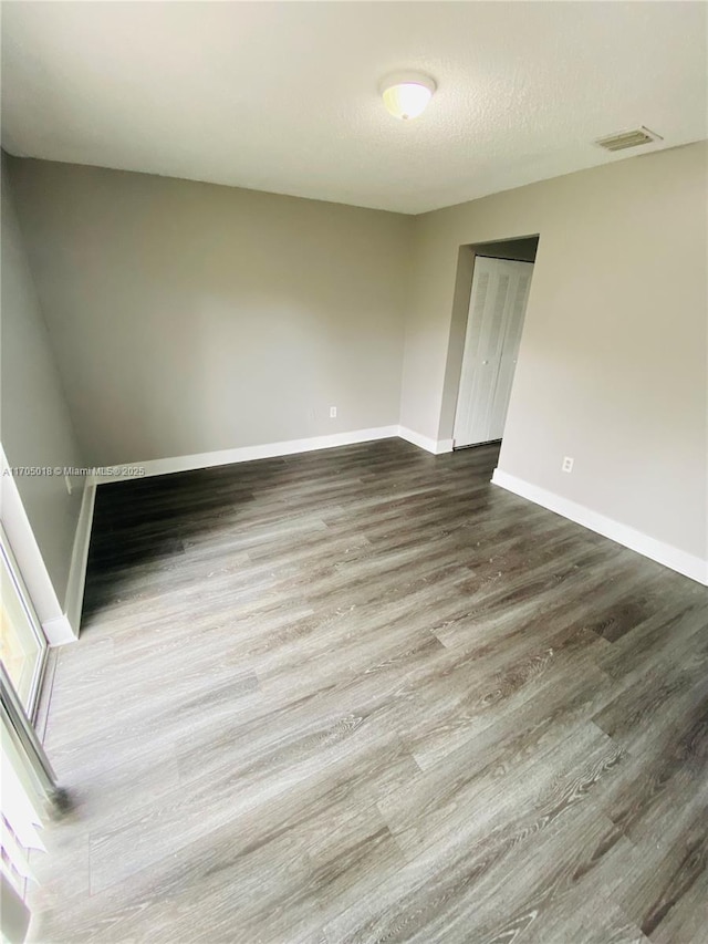 empty room featuring wood-type flooring and a textured ceiling