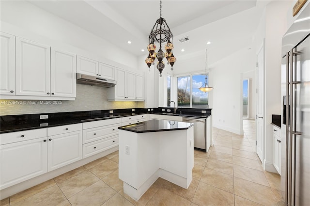 kitchen featuring decorative light fixtures, a center island, stainless steel appliances, and white cabinetry