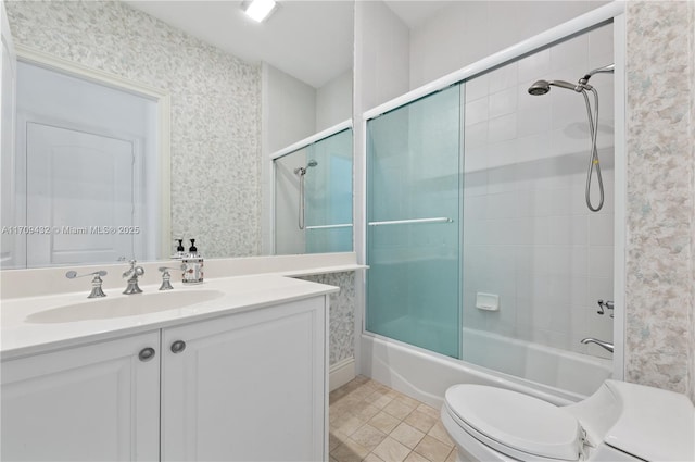 full bathroom featuring shower / bath combination with glass door, tile patterned floors, vanity, and toilet