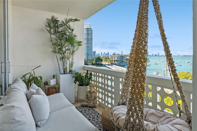 balcony with a water view and an outdoor hangout area