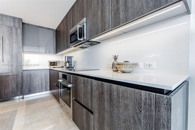 kitchen with appliances with stainless steel finishes and dark brown cabinets