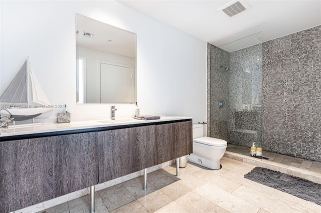 bathroom featuring tiled shower, vanity, and toilet