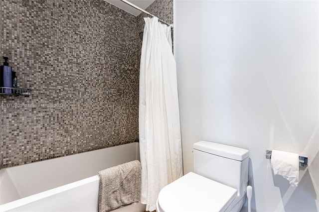 bathroom with toilet and shower / bath combo with shower curtain