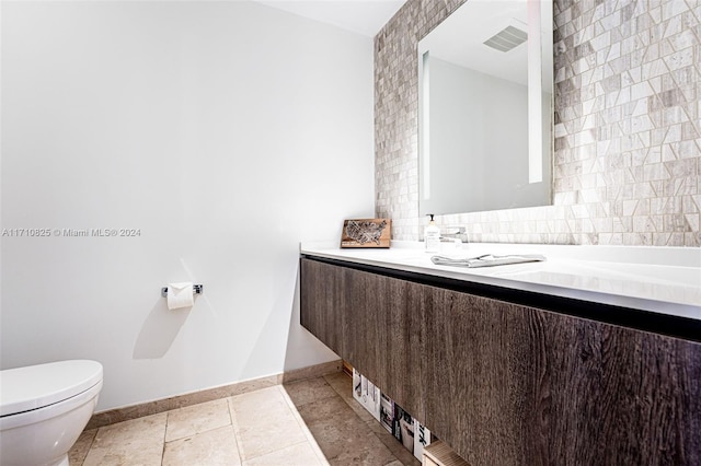 bathroom with vanity, toilet, and backsplash