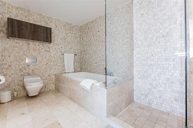 bathroom with toilet, tile walls, and tiled tub