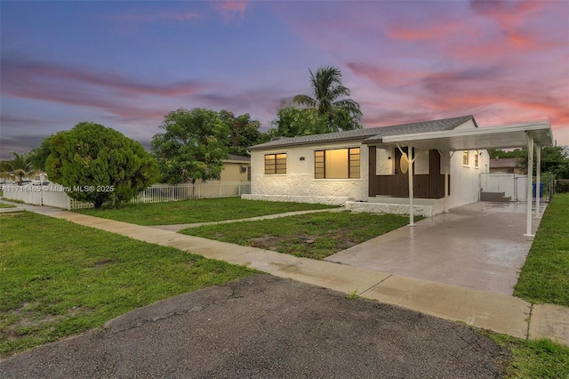 view of front of home with a yard and a carport