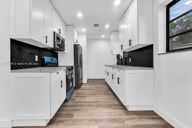 kitchen featuring light hardwood / wood-style flooring, white cabinets, and appliances with stainless steel finishes