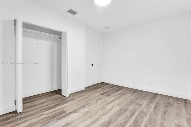 unfurnished bedroom featuring a closet and wood-type flooring