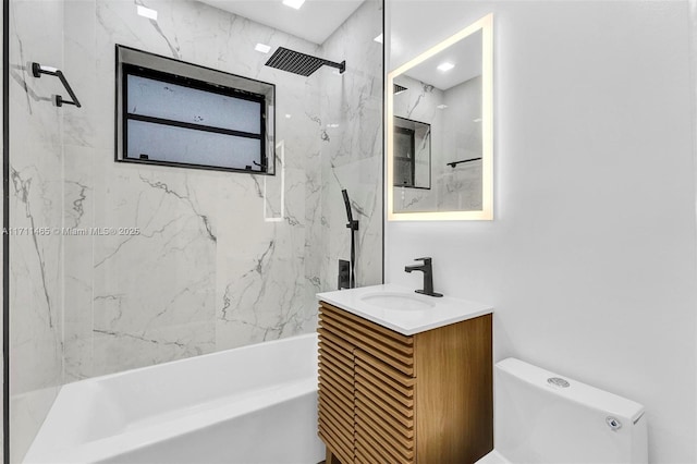 full bathroom featuring tiled shower / bath combo, toilet, and vanity