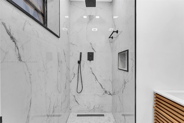 bathroom with vanity and tiled shower