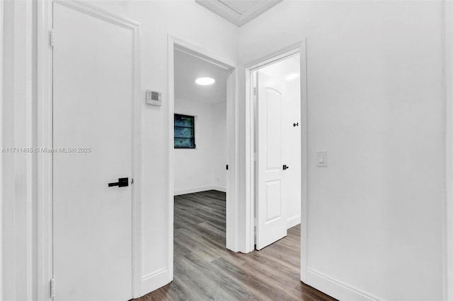 hallway with hardwood / wood-style flooring